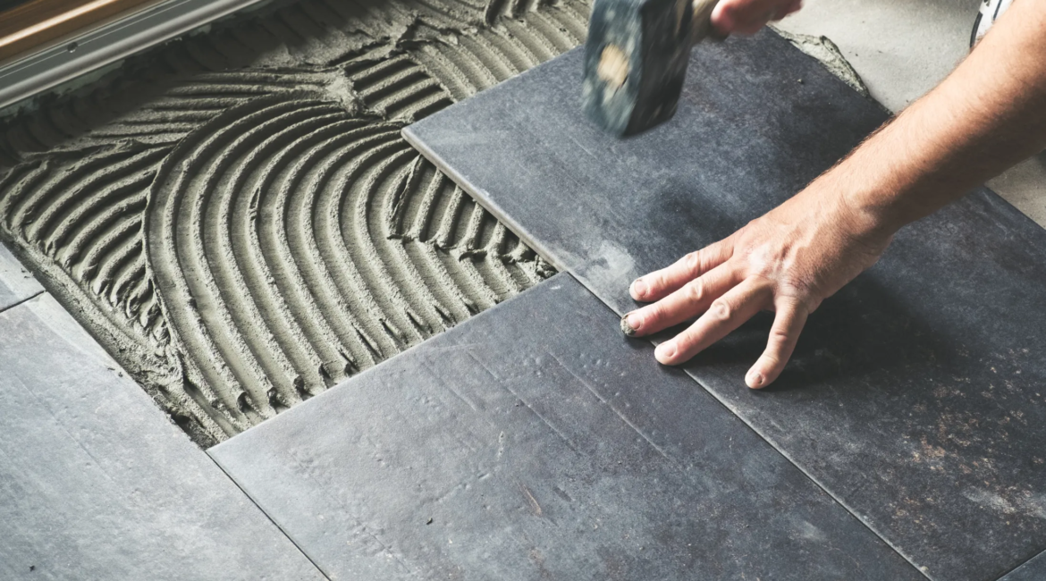 handyman installing ceramic tile flooring in Toronto home