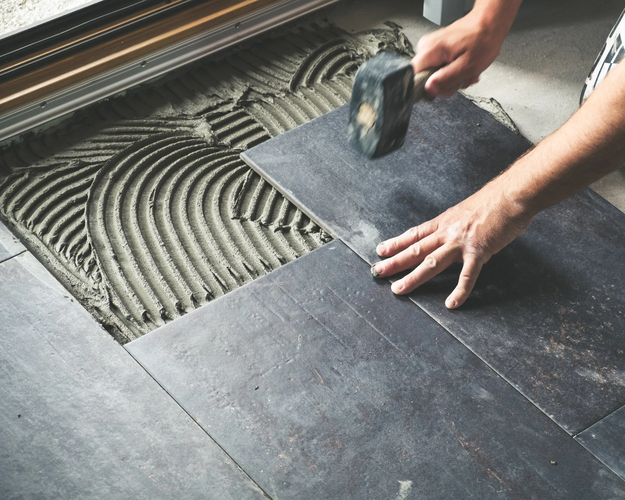 handyman installing ceramic tile flooring in Toronto home