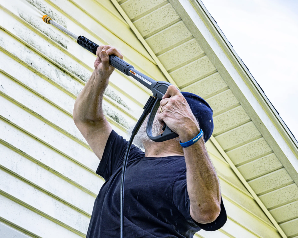worker pressure washing patio tiles in Toronto backyard