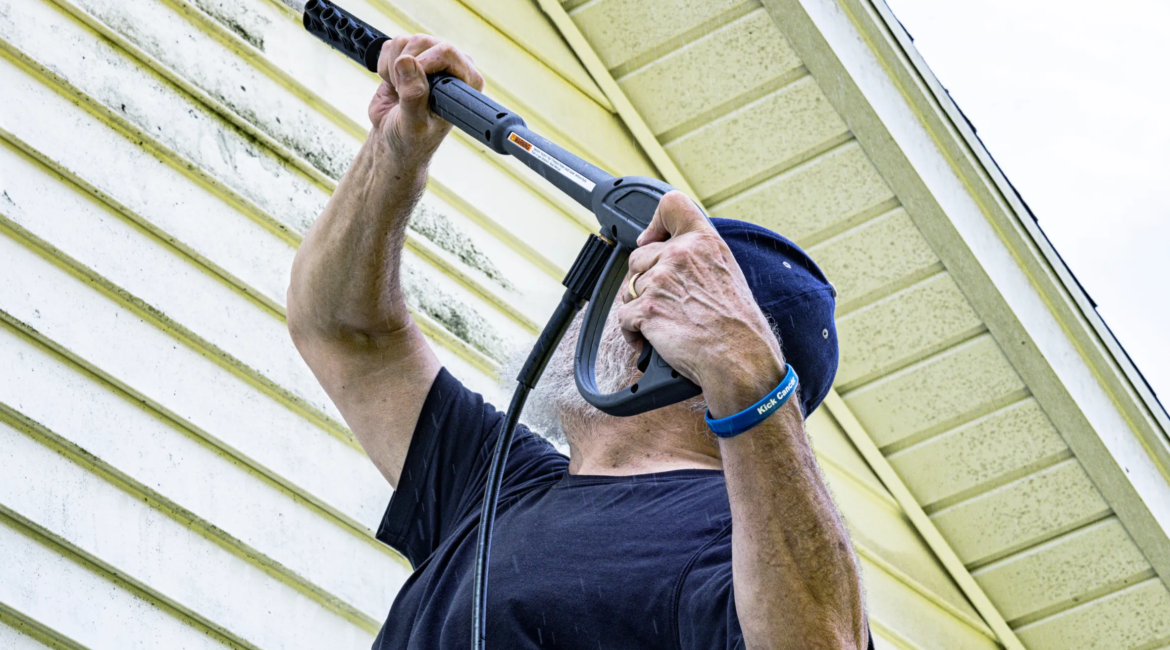 worker pressure washing patio tiles in Toronto backyard