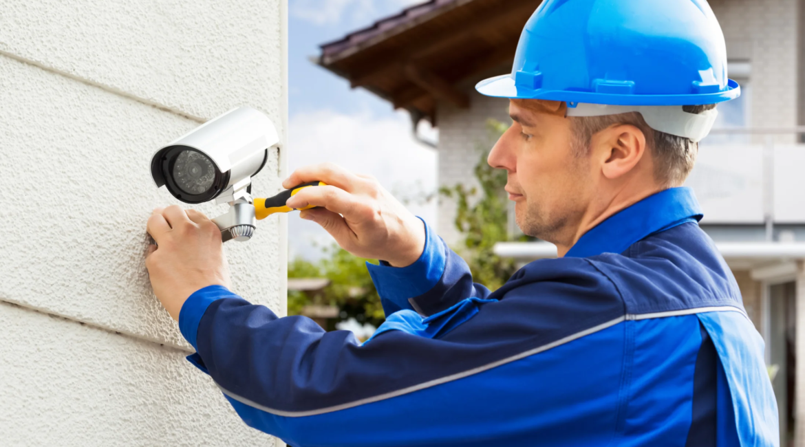 technician installing outdoor security camera on Toronto building