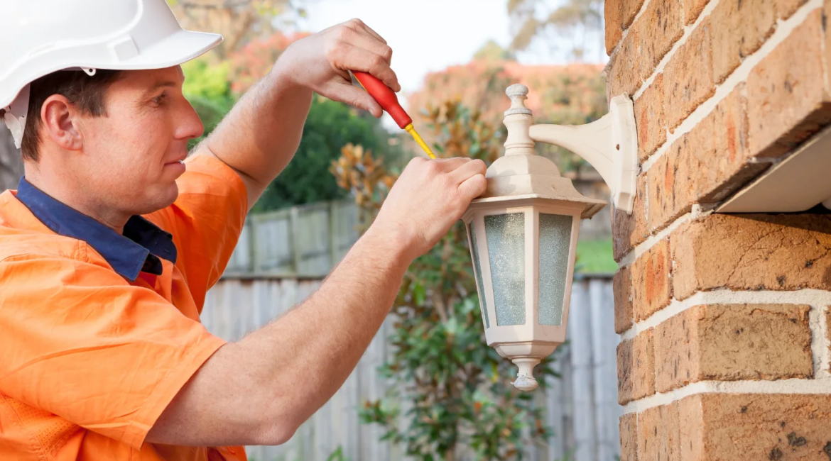electrician installing outdoor lighting fixtures on Toronto home
