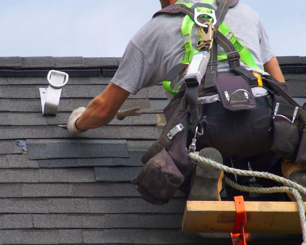 roofer repairing damaged roof shingles on Toronto house