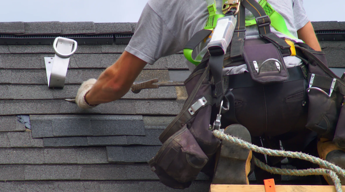 roofer repairing damaged roof shingles on Toronto house