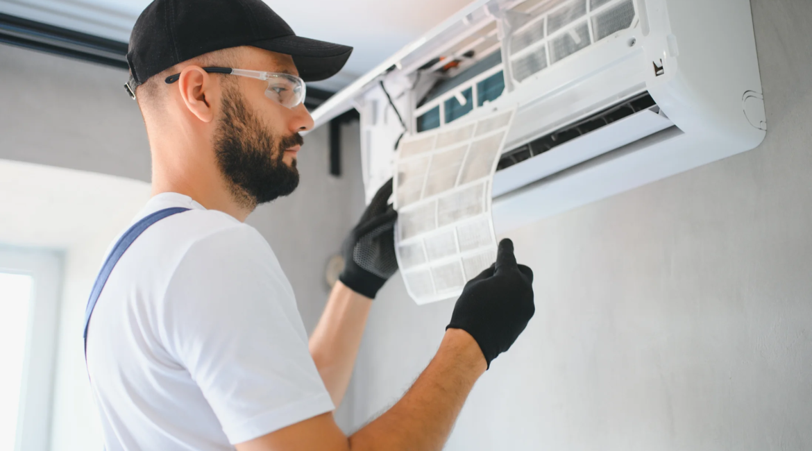 Technician repairing an air conditioner and checking refrigerant levels.