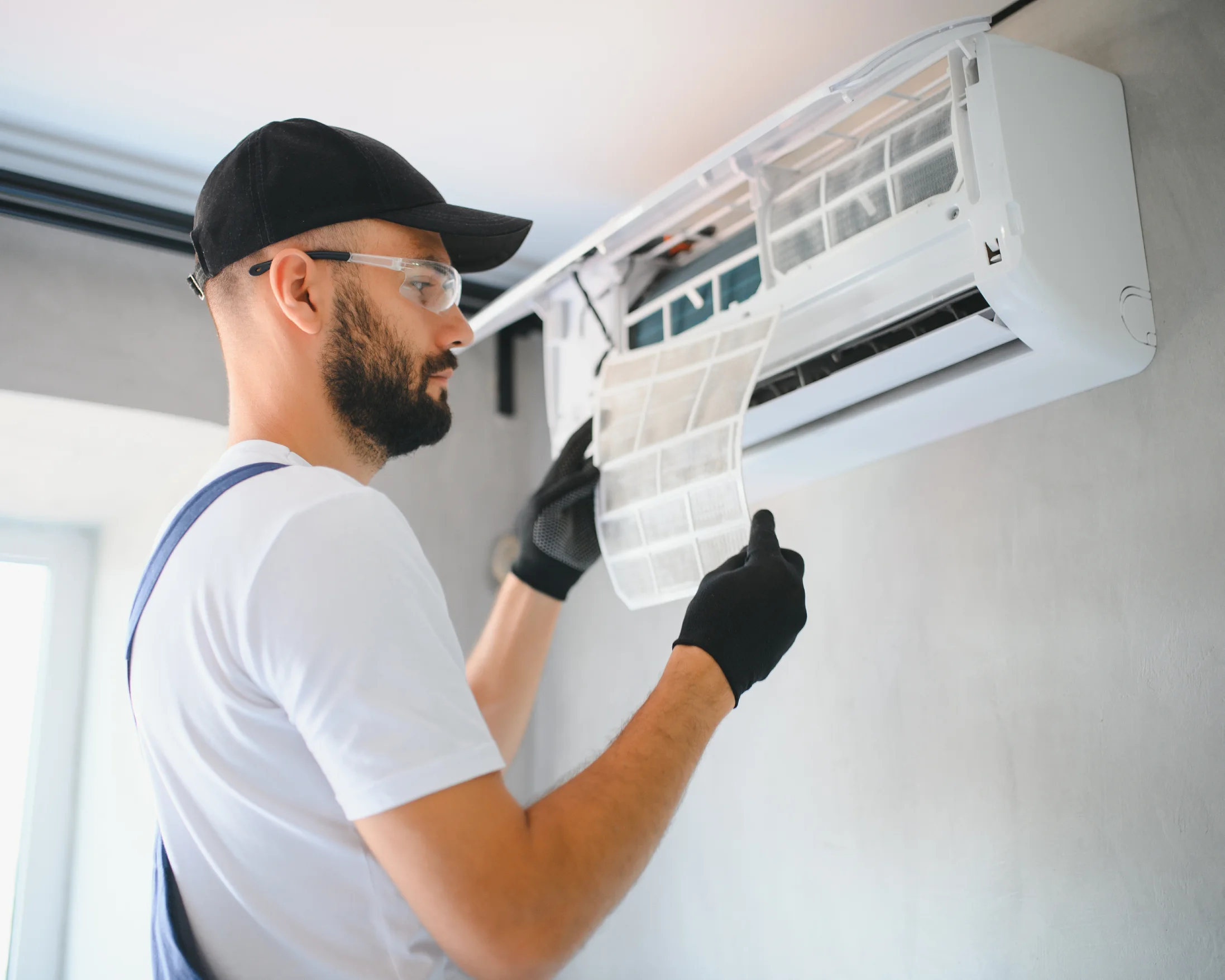 Technician repairing an air conditioner and checking refrigerant levels.