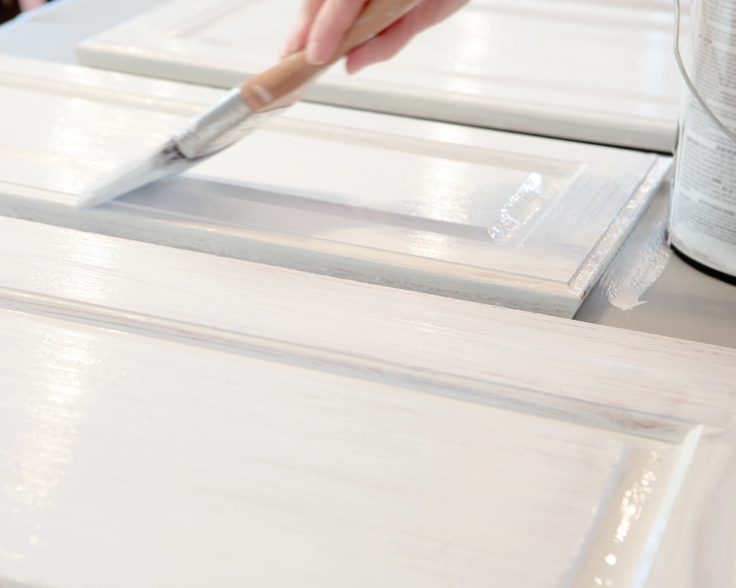 Painter refinishing and repainting kitchen cabinet doors