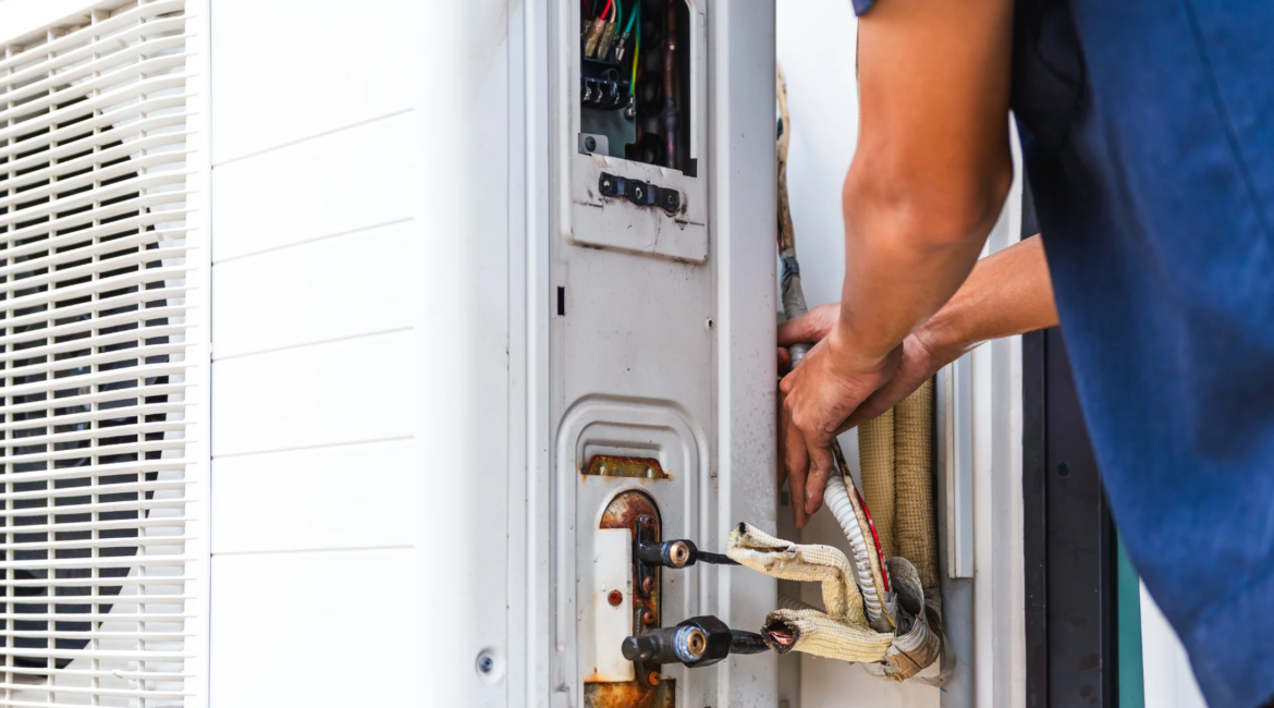 Technician inspecting and repairing a residential heat pump unit.