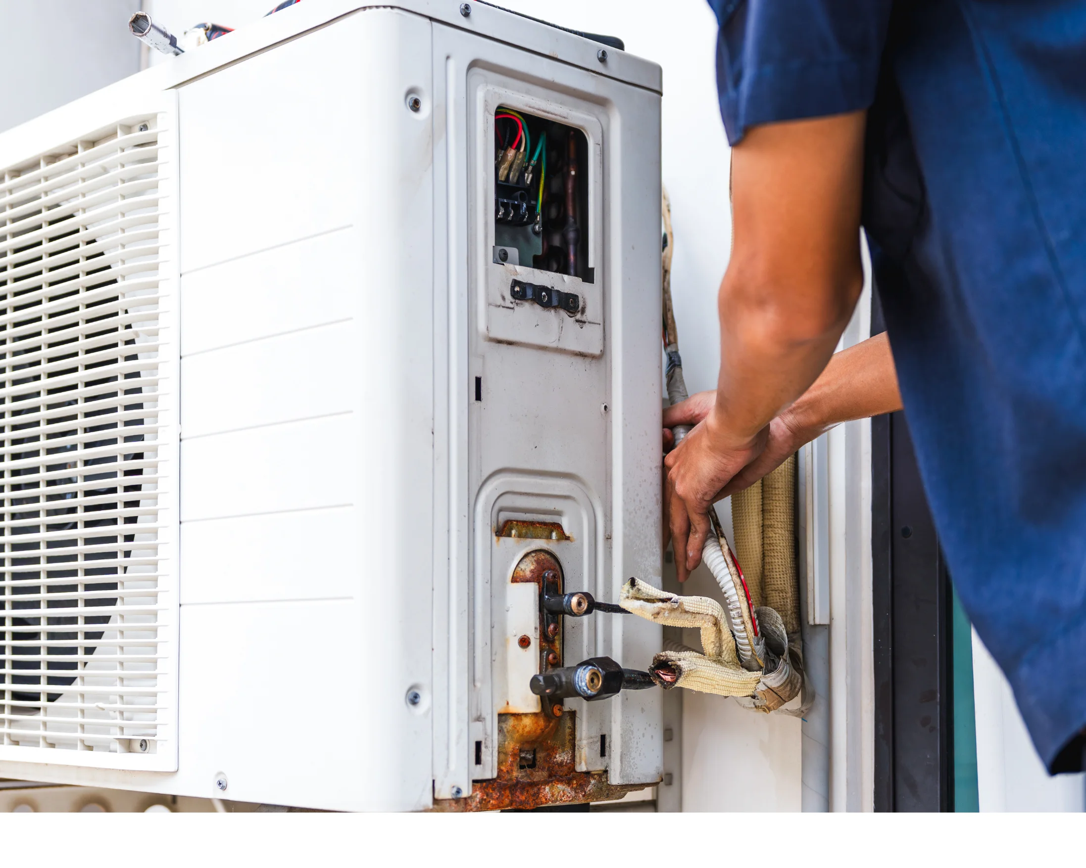 Technician inspecting and repairing a residential heat pump unit.