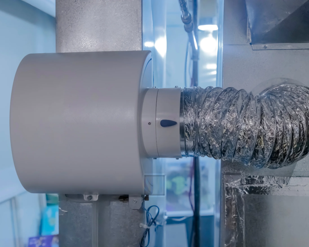 Technician installing a home humidifier connected to HVAC system.
