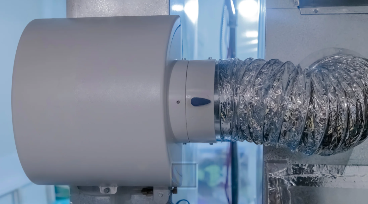 Technician installing a home humidifier connected to HVAC system.