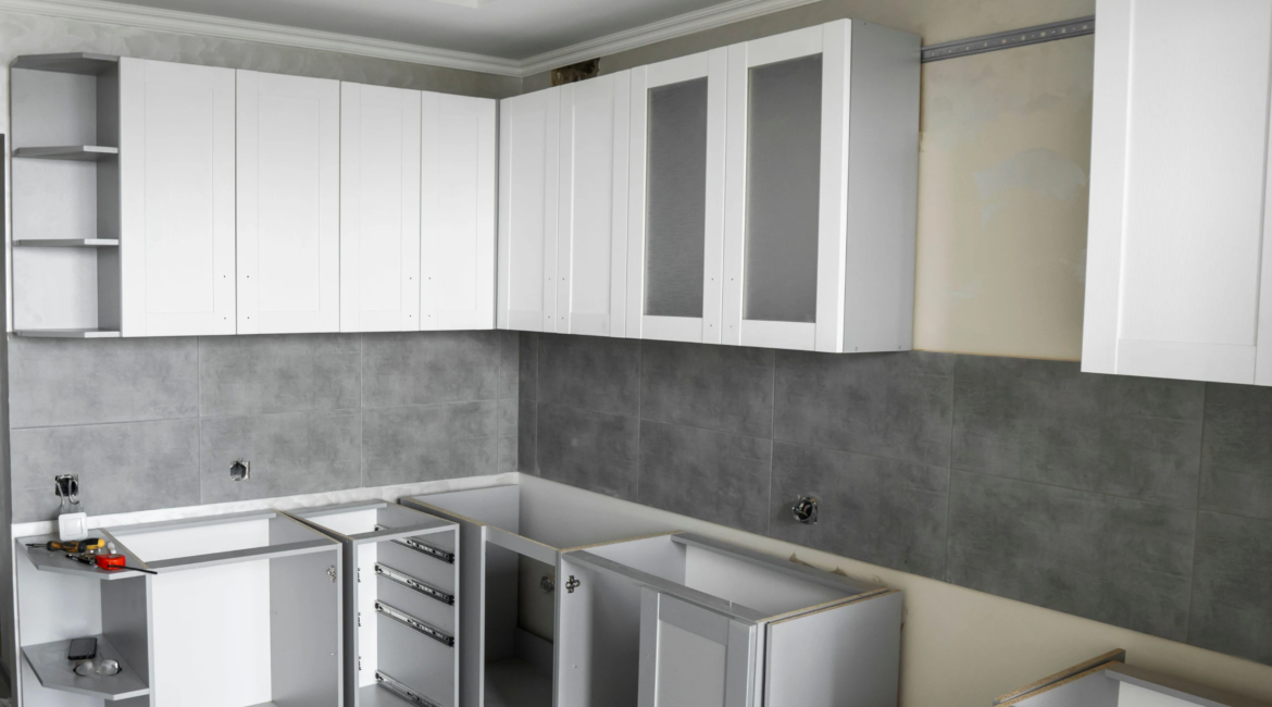 Technician installing new kitchen cabinets in a modern Toronto kitchen