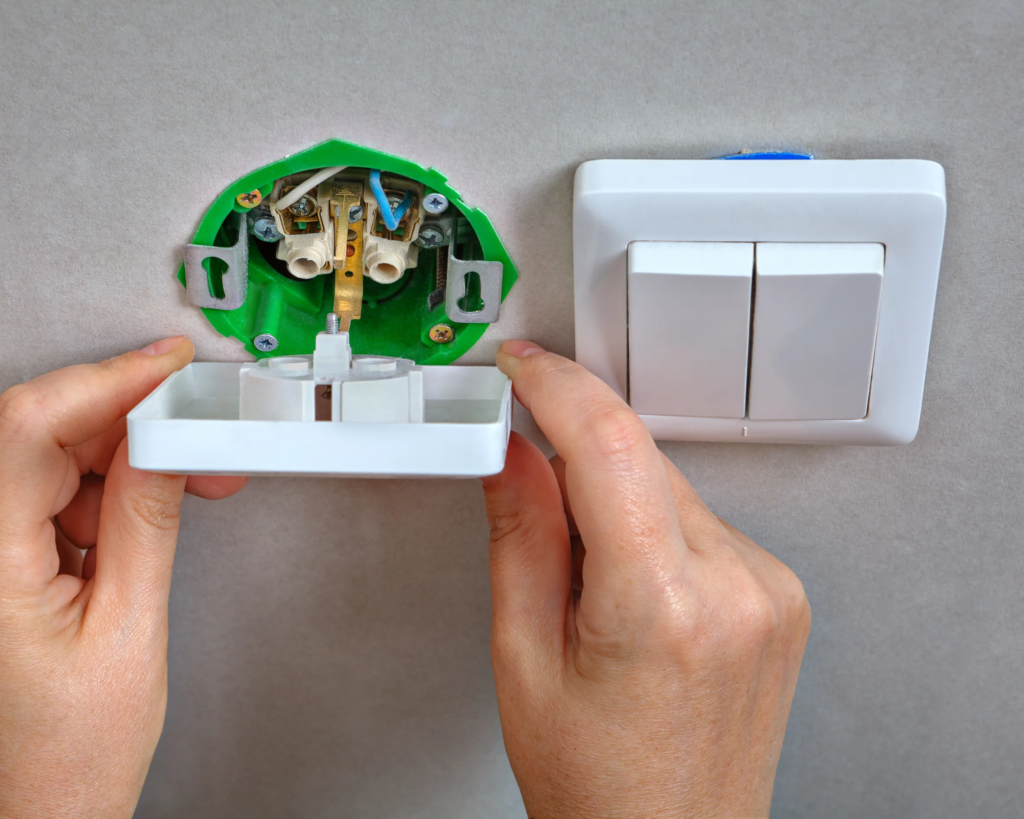 Electrician replacing a modern switch and USB outlet in a Toronto home.